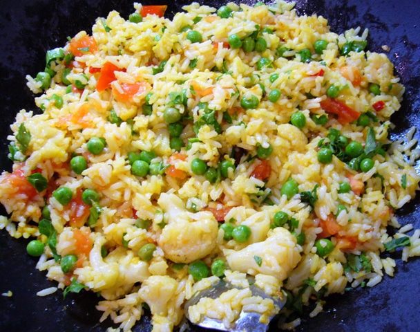 Пряный рис с цветной капустой, зеленым горошком и помидорами